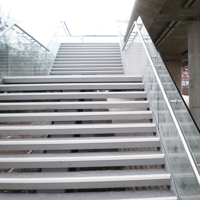 Glass balustrade along a steel staircase outdoors